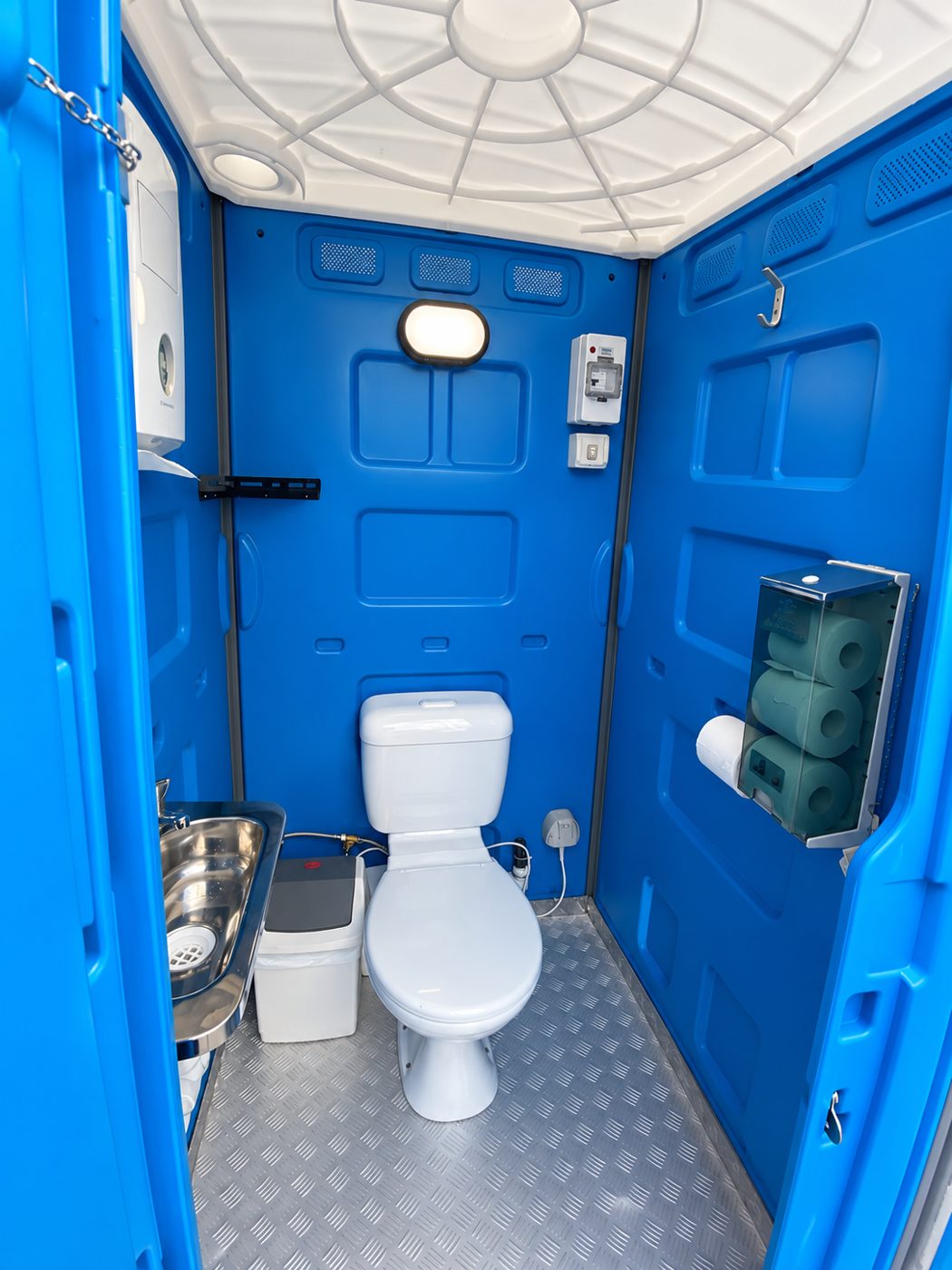 Inside a blue unit: toilet, basin and toilet roll dispenser